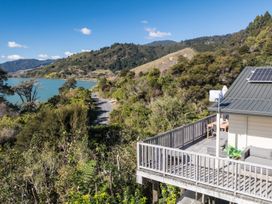 A balcony showing a view of mountains and water at Charlotte's Cottage - Havelock Holiday Home Marlborough
