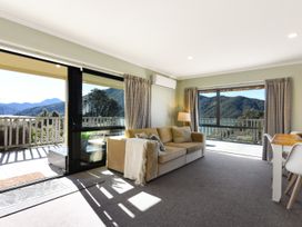A living room with a sofa, lamp and windows at Charlotte's Cottage - Havelock Holiday Home Marlborough