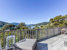 A deck with furniture overlooking a lake at Charlotte's Cottage - Havelock Holiday Home Marlborough