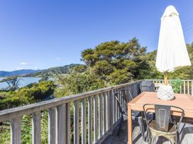An outdoor dining area with a table and umbrella at Charlotte's Cottage - Havelock Holiday Home in Marlborough
