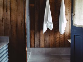 A bathroom with towels hanging and a shower area at The Shearers Quarters Clarence Farmstay in Kaikoura