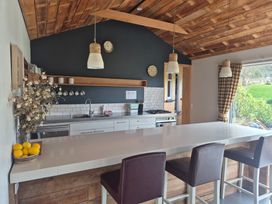 A kitchen with a countertop and bar stools at The Shearers Quarters - Kaikoura
