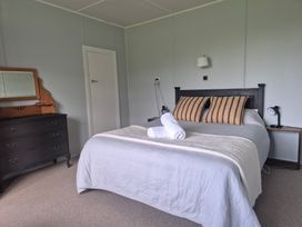 A bedroom with a bed and dressing table at The Shearers Quarters - Kaikoura