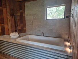 A bathroom with a bathtub and towels at The Shearers Quarters - Kaikoura Holiday Home in Kaikoura