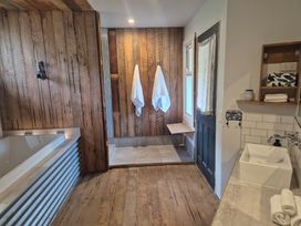 A bathroom with a bathtub and shower area at The Shearers Quarters - Kaikoura Holiday Home