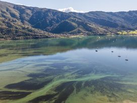 A view of water and boats near mountains at Koraha Serenity - Linkwater Holiday Home Marlborough