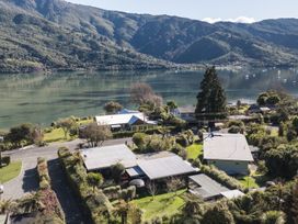 An aerial view of houses and a lake surrounded by mountains at Koraha Serenity - Linkwater Holiday Home Marlborough