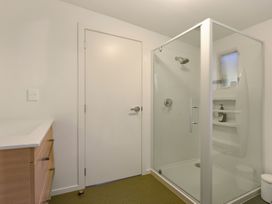 A bathroom with a shower, cabinet, and toilet at Koraha Serenity - Linkwater Holiday Home Marlborough