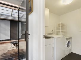 A laundry room with a washing machine and a sink at Koraha Serenity - Linkwater Holiday Home, Marlborough