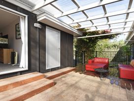 A patio with red furniture and steps at Koraha Serenity - Linkwater Holiday Home Marlborough