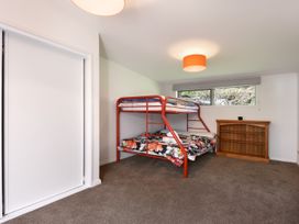 A bedroom with a bunk bed and wooden shelf at Koraha Serenity - Linkwater Holiday Home Marlborough