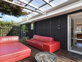 An outdoor seating area with red sofas and a fire pit at Koraha Serenity - Linkwater Holiday Home Marlborough