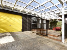 An outdoor area with a yellow garage door and seating at Koraha Serenity - Linkwater Holiday Home Marlborough