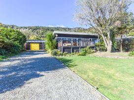 A house with a gravel driveway and garage at Koraha Serenity - Linkwater Holiday Home Marlborough