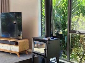 A living room with a television and fireplace at Koraha - Queen Charlotte Sound Holiday Home, Marlborough