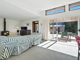 A living room with a sofa and a fireplace at Maison Pierre Rouge - Duvauchelle Holiday Home, Akaroa
