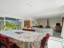 A living room with a table and chairs at Maison Pierre Rouge - Duvauchelle Holiday Home, Akaroa