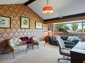 A living room with seating and decorative wall art at Maison Pierre Rouge - Duvauchelle Holiday Home, Akaroa