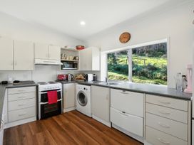A kitchen with appliances and a window at Maison Pierre Rouge - Duvauchelle Holiday Home, Akaroa