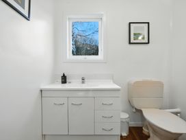 A bathroom featuring a sink and toilet at Maison Pierre Rouge - Duvauchelle Holiday Home Akaroa