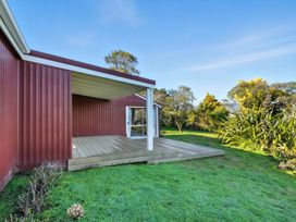 An outdoor deck area with grass and garden at Maison Pierre Rouge - Duvauchelle Holiday Home in Akaroa