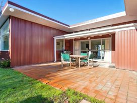 An outdoor patio with a table and chairs at Maison Pierre Rouge - Duvauchelle Holiday Home, Akaroa