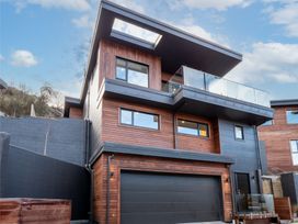 A house with a balcony and garage at Remarkable QT - Queenstown Holiday Home in Queenstown