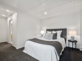 A bedroom with a bed and bedside tables at Remarkable QT - Queenstown Holiday Home Queenstown