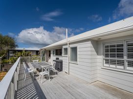 A deck with a table and chairs at a property in an outdoor setting