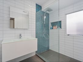 A bathroom with a shower, mirror, and sink at the property