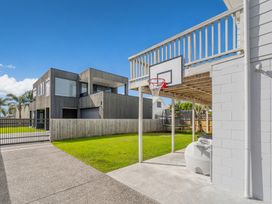 An outdoor space with a basketball hoop and trampoline at a residential property