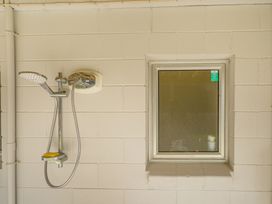 A shower with a showerhead and a window at the property