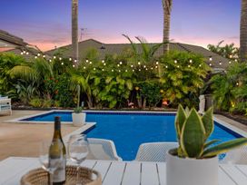 An outdoor area with a swimming pool and seating at JB's Sanctuary - Papamoa Holiday Home, Papamoa