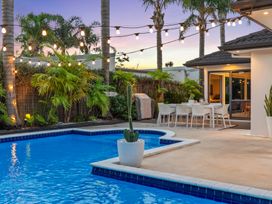 An outdoor area with a swimming pool and dining set at JB's Sanctuary - Papamoa Holiday Home, Papamoa