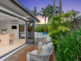 An outdoor area with seating and a swimming pool at JB's Sanctuary - Papamoa Holiday Home Papamoa