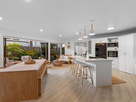 A kitchen with an island and bar stools at JB's Sanctuary - Papamoa Holiday Home, Papamoa
