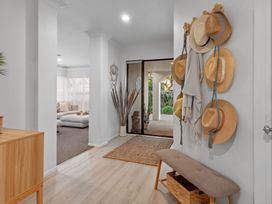 A hallway with a bench and hats hanging at JB's Sanctuary - Papamoa Holiday Home, Papamoa