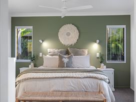 A bedroom with a bed and bedside tables at JB's Sanctuary - Papamoa Holiday Home