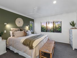 A bedroom with a bed and window light at JB's Sanctuary - Papamoa Holiday Home in Papamoa