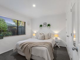 A bedroom with a bed and nightstand at JB's Sanctuary - Papamoa Holiday Home, Papamoa