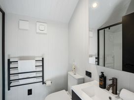 A bathroom with a sink and towel rack at Pinnacle Peaks - Queenstown Holiday Home in Queenstown