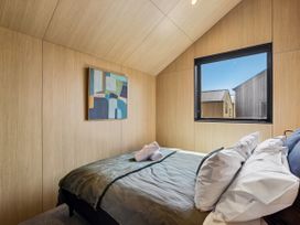A bedroom with a bed and window at Pinnacle Peaks - Queenstown Holiday Home in Queenstown