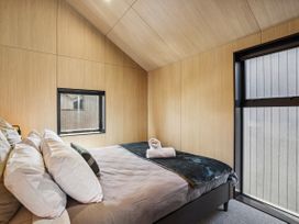 A bedroom with a bed and window at Pinnacle Peaks - Queenstown Holiday Home in Queenstown