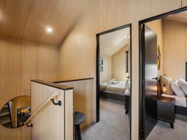 A bedroom with a bed and nightstand at Pinnacle Peaks - Queenstown Holiday Home in Queenstown