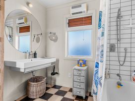 A bathroom with a washbasin and a shower at Oli Kai - Algies Bay Holiday Home in Algies Bay