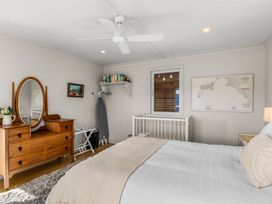 A bedroom with a bed and dresser at Oli Kai - Algies Bay Holiday Home in Algies Bay