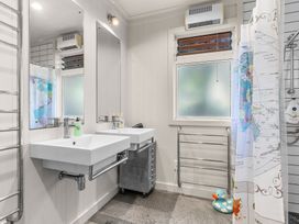 A bathroom with two sinks and a shower at Oli Kai - Algies Bay Holiday Home, Algies Bay