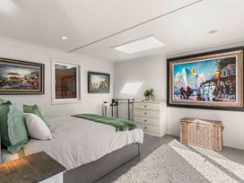 A bedroom with a bed and paintings at Oli Kai - Algies Bay Holiday Home in Algies Bay