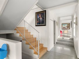 A hallway with stairs and paintings at Oli Kai - Algies Bay Holiday Home in Algies Bay