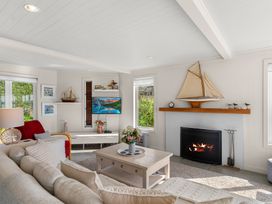 A living room with a fireplace and sofa at Oli Kai - Algies Bay Holiday Home in Algies Bay